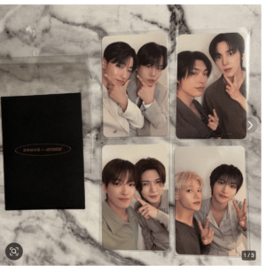 Set of four glossy photo cards showing two young men posing for selfies on a marble surface, with a black box featuring an orange logo to the left.