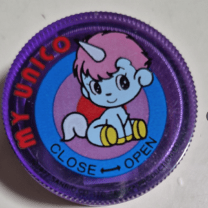 Purple bottle cap showing a cute pink unicorn, with blue and pink circles, and the words 'CLOSE' and 'OPEN' with arrows for opening/closing.