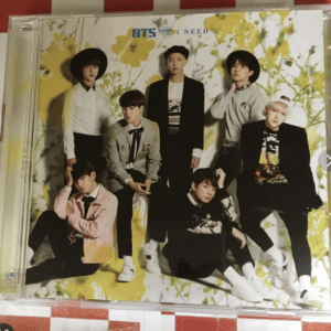 Seven BTS members pose in fashionable outfits against a bright yellow floral backdrop; 'BTS NEED U' text visible. (Album cover)