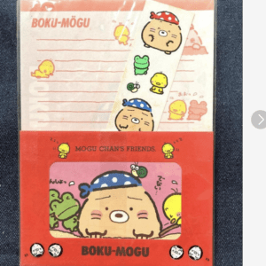 Red packaging featuring a cute blob-like character with a blue bandana in a window, surrounded by small yellow and green characters; includes the text 'BOKU-MOGU' and 'MOGU CHAN'S FRIENDS' on the box.