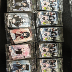 Two vertical columns of sealed anime trading card packs laid out on a dark surface, neatly arranged in rows.  Articulos Japan (Post Box Japan)