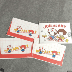 Set of Jon and Amy cartoon stationery, including envelopes and a 'Jon and Amy' picnic card with red accents.