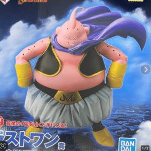Large figure of Majin Buu from Dragon Ball, in fat form with cape, vest, and yellow cuffs, posed against a blue cloudy backdrop on a rocky surface.