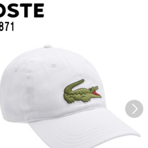 White baseball cap with a green Lacoste crocodile logo on the front.
