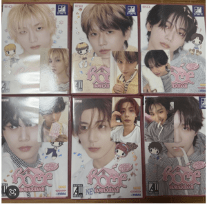 A grid of six pink-covered album boxes featuring close-up photos of young men, with cute cartoon stickers and glitter accents on each cover.