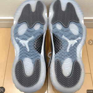 Bottom view of two athletic sneakers showing translucent blue soles with dark gray chevron traction patterns in the tread area.