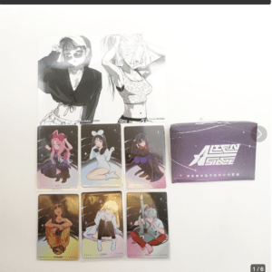 Collection of collectible anime character cards laid out on a white surface, with two black‑and‑white posters above and a purple packaging box on the right.