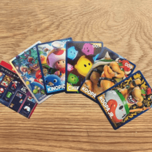 Fanned set of colorful cartoon character trading cards spread on a wooden table.