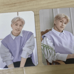 Two photo cards showing a blond young man in a lavender sweater over a white shirt, posed indoors on a wooden table.