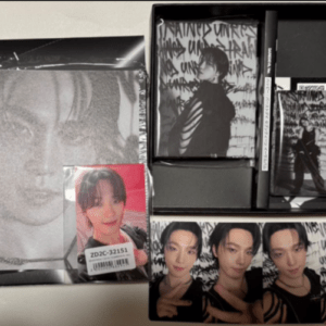 Boxed music merchandise set featuring a grayscale poster, a red photo card, and multiple glossy photos of a male idol.