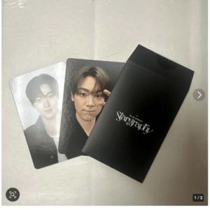 Two glossy portrait photos of a young man resting on a black textured folder or portfolio with a white 'Stargraphy' logo visible on the cover.