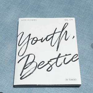 White book with large black cursive words 'Youth, Bestie' on a blue textured background.