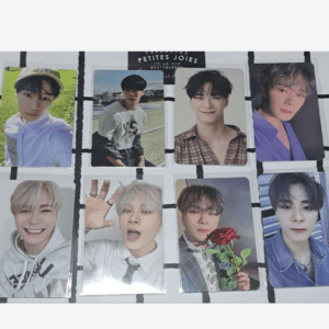 Eight glossy photocards of a male K-pop group laid out in a grid on a white surface, each card featuring a different member portrait.