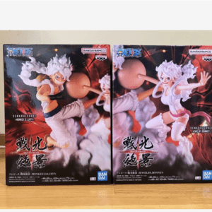 Two boxed One Piece action figure sets displayed side by side on a wooden surface, featuring dynamic fighting poses and Bandai logos on the packaging.  Articulos Japan (Post Box Japan)