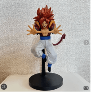 Action figure of a Dragon Ball character with spiky red hair leaping forward, arms extended, tail visible behind, on a black stand.
