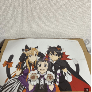 Three anime characters in Halloween costumes with cat ears and pumpkins, posing together and smiling in front of a white background poster.  Articulos Japan (Post Box Japan)