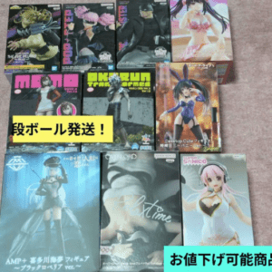Assorted boxed anime figures arranged on a carpet, showing characters in colorful outfits and dynamic poses.