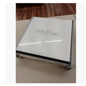 Angled view of a white Sony PlayStation box on a table, with the PS logo visible on the lid and the console protruding slightly.