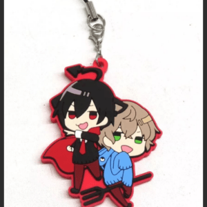 Chibi anime keychain showing two characters riding a red broom; one with black hair in a suit, the other with brown hair in a blue hoodie, attached to a silver chain.
