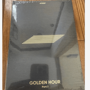 Sealed black ATEEZ album box labeled 'GOLDEN HOUR Part.1' with gold diagonal stripes, resting on a wooden floor.