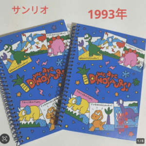 Two bright blue spiral notebooks opened to reveal colorful dinosaur illustrations and the slogan 'We are DINOSAUR!'; red '1993年' text sits above.