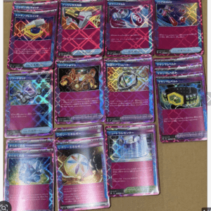 Row of pink-bordered Pokémon TCG cards with metallic gadgets laid on a brown surface.
