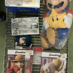 Large Mario plush in red hat and blue overalls holding a yellow star on store shelf with Bowser figure box nearby