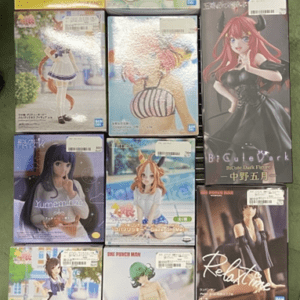 Display rack with twelve boxed anime figure collectibles arranged in three columns on a store shelf.