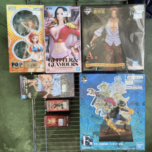 Assorted anime figure boxes on a metal rack, featuring colorful packaging and character designs from various series.