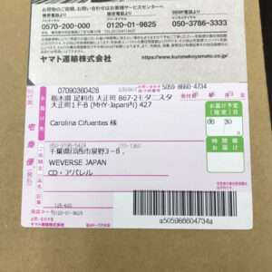 Front of a cardboard box showing a Japanese shipping label with recipient Carolina Cifuentes 様, barcode and tracking number, and pink/green delivery sections.