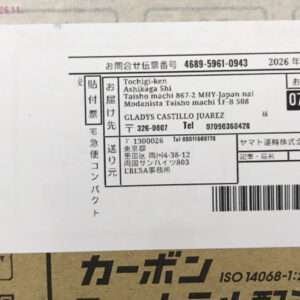 White Japanese delivery label on a cardboard box, showing recipient details, a barcode, and the date 07/05.