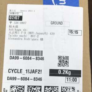 Shipping label on a cardboard box showing recipient Alexandra Rodriguez, weight 0.2 kg, service GROUND, barcode, and times 15:15 and 11:00.  Articulos Japan (Post Box Japan)