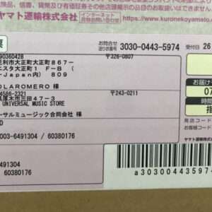 Japanese shipping label with sender/recipient addresses, barcode, and delivery date details.