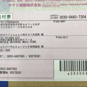 Shipping label with sender and recipient addresses, phone numbers, and a barcode on a pink-tade label block.”
