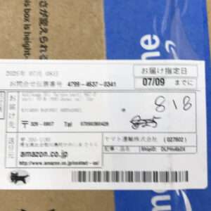 Cardboard box with a white shipping label containing Japanese text, a barcode, and the date 07/09 on the label.