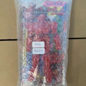 Bubble-wrapped colorful box resting on cardboard, with two white labels reading 555 and 74087.