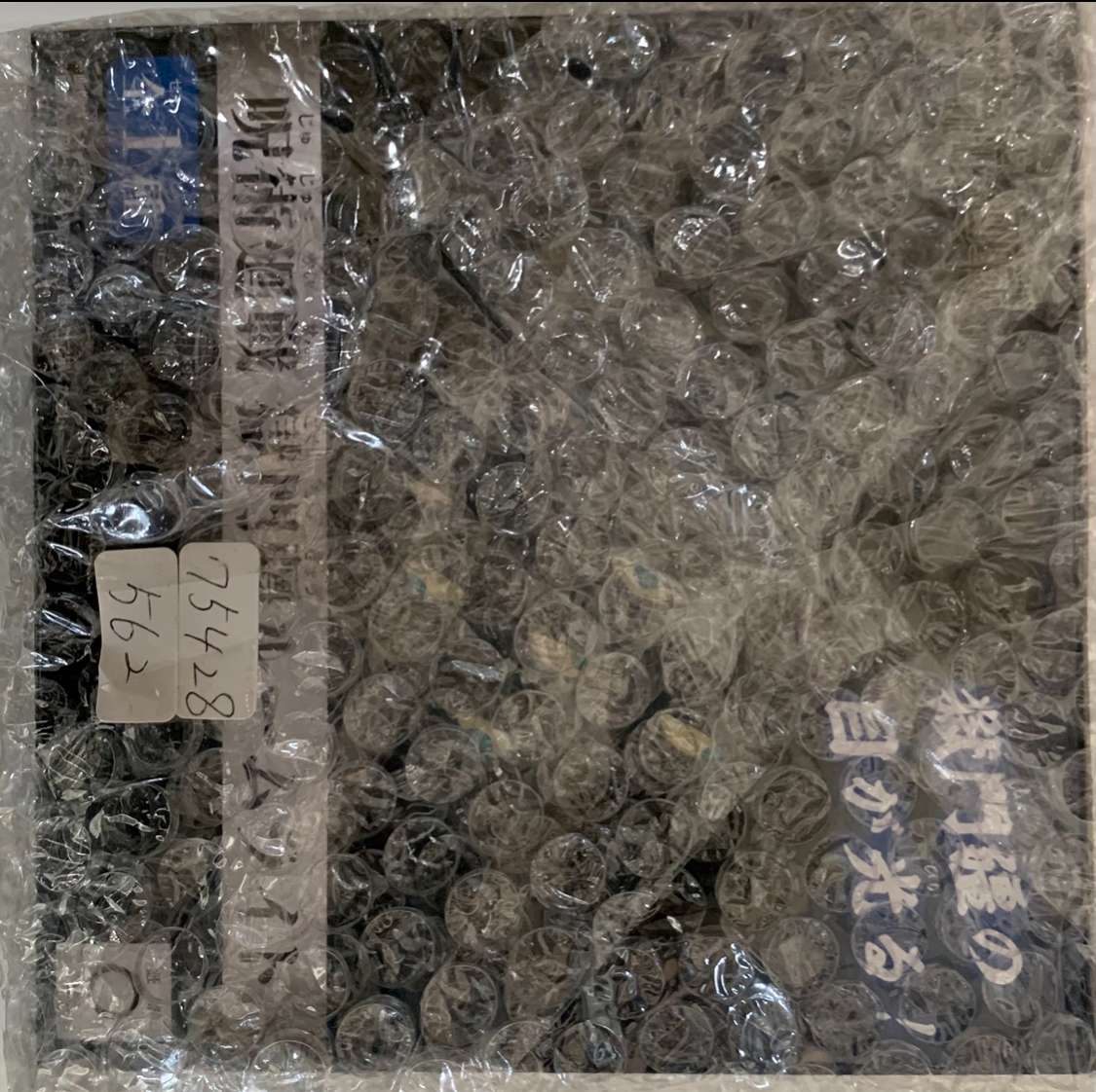 Img_2573 - Articulos Japan (post Box Japan) Box filled with many small transparent vials wrapped in bubble wrap; labels with handwritten numbers are attached nearby Articulos Japan (Post Box Japan)