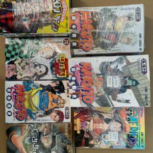 Stack of wrapped Naruto manga volumes laid out on a cardboard surface, showing colorful Japanese covers and price stickers still on the plastic wrap.