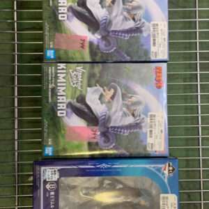 Row of six boxed anime figures lined up on a metal wire shelf; top box features a dark-haired swordsman (Kirito) and the others have colorful artwork and price stickers on their fronts.