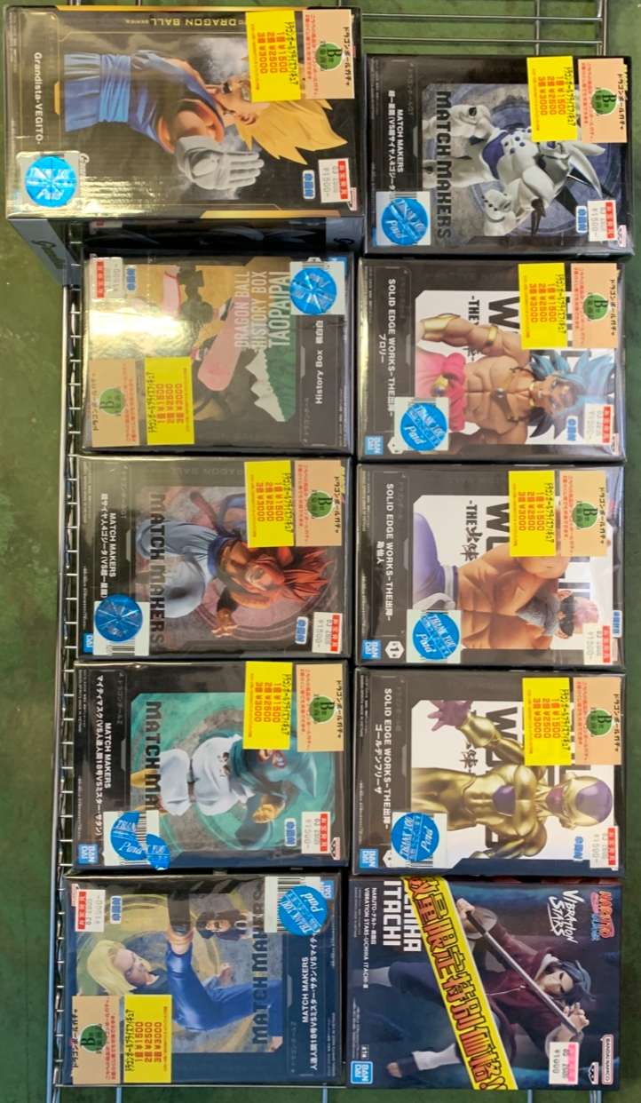 Img_2744 - Articulos Japan (post Box Japan) Row of boxed anime figure sets on a metal display rack with yellow sale stickers visible on several boxes. Articulos Japan (Post Box Japan)