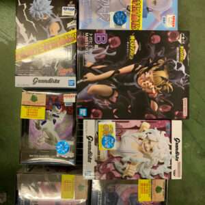 Collection of anime action figure boxes on a metal rack, featuring Naruto Grandista and Dragon Ball characters.