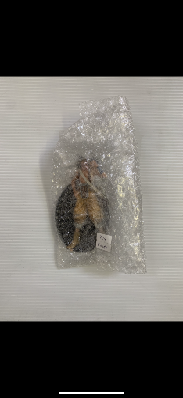 Img_2836 3 - Articulos Japan (post Box Japan) Bubble-wrapped package containing a black oval object with tan straps on a light striped surface . Articulos Japan (Post Box Japan)