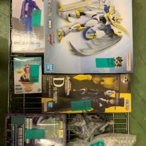 Assorted anime figure boxes on a metal rack, including a large white-gold armored model and blue-skinned character boxes with price tags.