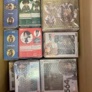Box filled with many small bubble-wrapped collectible figure boxes in assorted colors (blue, green, red, yellow) ready for shipment or storage.