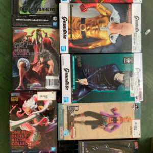 Boxed anime action figures arranged on a metal rack, including One Piece Battle Record Collection boxes with colorful character art and other figure boxes nearby.