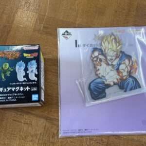 Dragon Ball Z mini figure magnet box with four small figures, placed next to a purple folder featuring Super Saiyan Goku in a dynamic pose.