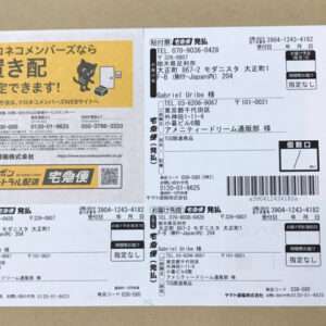 Sheet of Japanese delivery labels and invoices with a yellow advertisement panel on the left featuring a cat logo and text in Japanese.