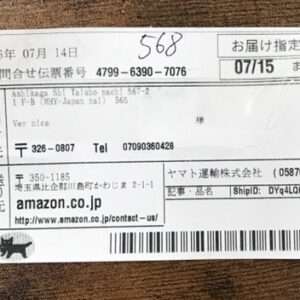 Japanese shipping label on a white sticker with date 2026-07-14, delivery date 07/15, tracking numbers, and a barcode; sender Amazon.co.jp and recipient details in Japanese.