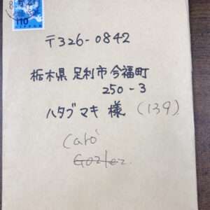 Beige envelope with a blue postage stamp in the top-left corner and handwritten Japanese address on the front.