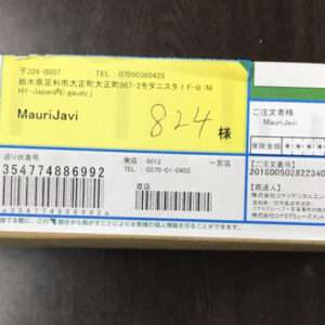 Box with a Japanese shipping label; a yellow sticker shows the name 'MauriJavi' and the handwritten number 824, with barcodes and other details visible.